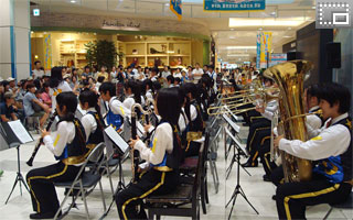 交通安全フェアにおいて、イオンモール銚子「イルカの広場」で演奏する本校吹奏楽部の写真です。